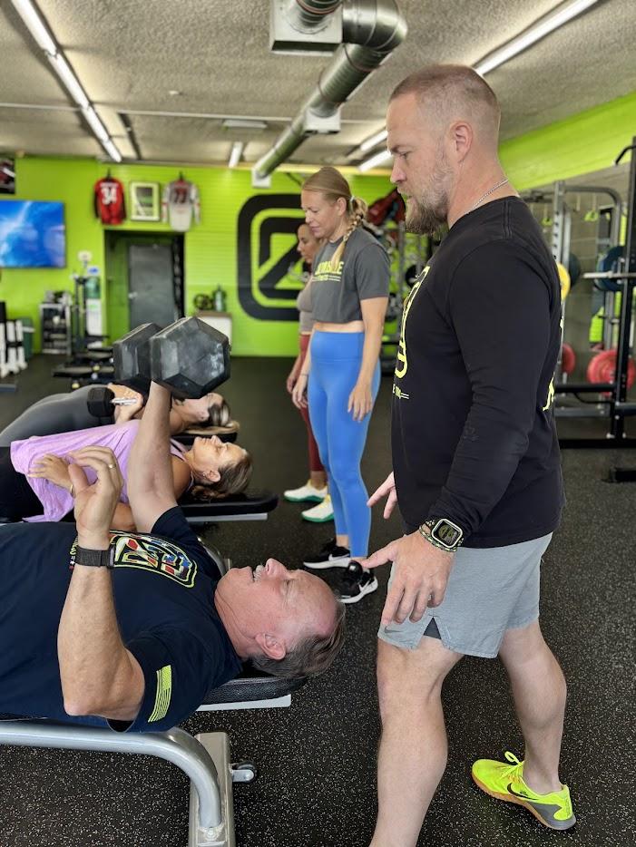 Coach spotting a member during bench press